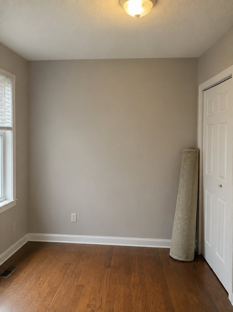 Bedroom after painting — clean warm beige walls, wooden floor, window and door, freshly repainted, smooth even finish