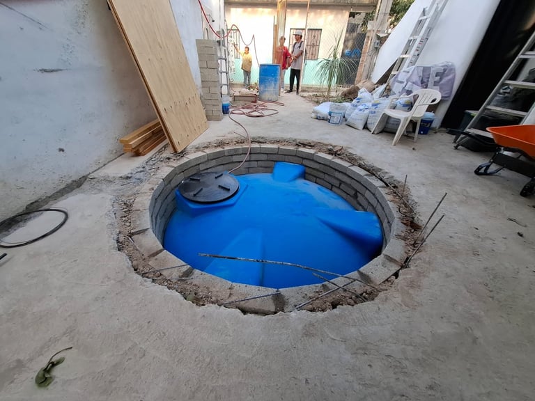 Blue water tank being installed in a concrete floor opening at a construction site