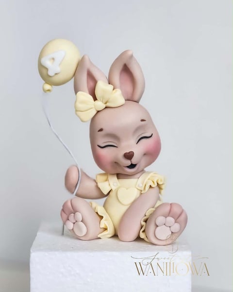 Pink ceramic bunny figurine with cream-colored bow and balloon details, sitting on white base with Waniilova logo