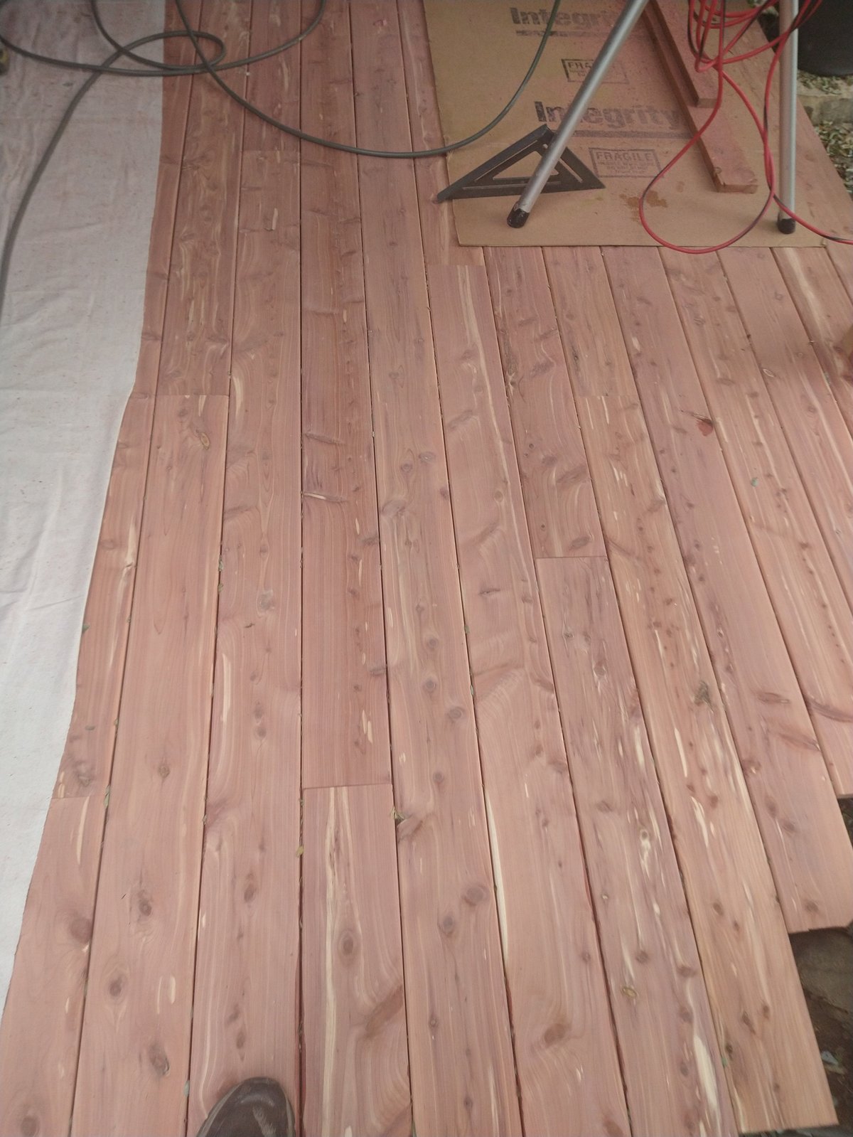 Wooden hardwood flooring laid out with installation tools and equipment visible on top