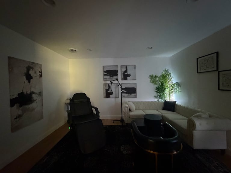 Modern office room with gaming chair, desk setup, wall art, potted plant, and recessed lighting