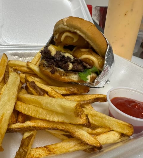 Cheeseburger with melted cheese and caramelized onions served with golden french fries and ketchup
