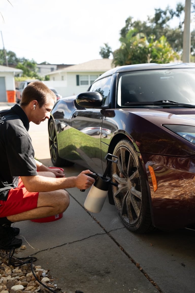JT hand-washing red sports car with foam on driveway
