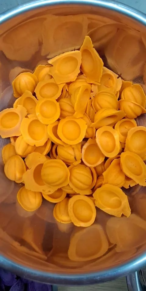 Heap of yellow plastic bottle caps in a clear container