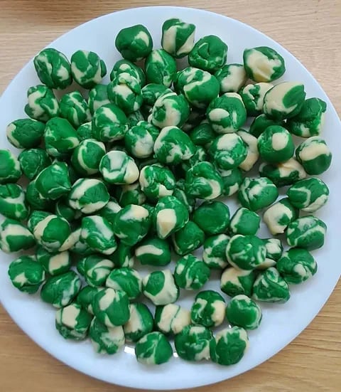 Sliced green bell peppers and white onions arranged on a white plate