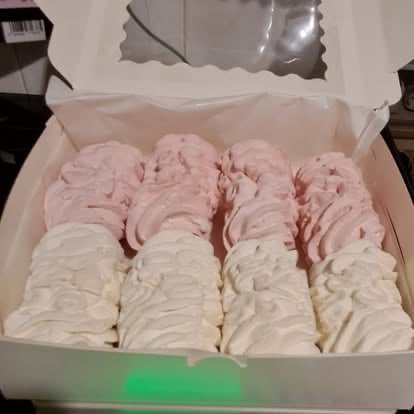 White box containing rows of pink and white frosted cupcakes arranged neatly in compartments