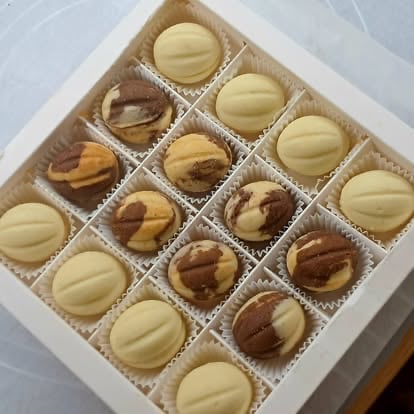 Assorted chocolate truffles in white box, including white chocolate and swirled varieties