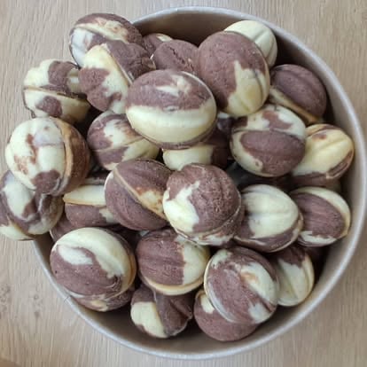 A white bowl filled with chocolate and vanilla swirl cookies arranged in a circular pattern