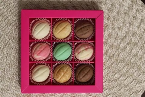 Pink makeup palette with nine eyeshadow shades in neutral and earthy tones, arranged in a 3x3 grid layout with decorative gold accents