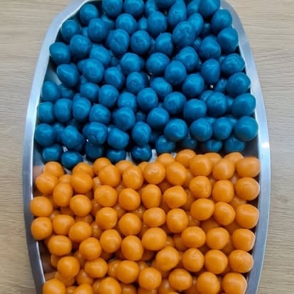 White oval platter with blue berries on top half and orange berries on bottom half, arranged in two sections