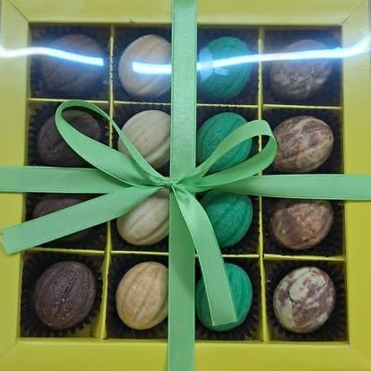 Assorted chocolates in green gift box with decorative ribbon bow
