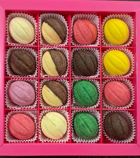 Box of 16 assorted colorful bonbons and truffles in pink wrapper compartments featuring chocolate, vanilla, strawberry, and matcha flavors