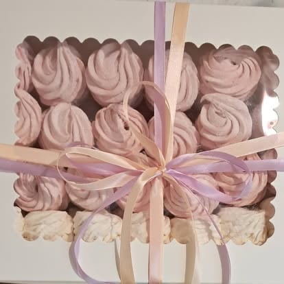 Box of pink and cream frosted cupcakes tied with pastel ribbons and bows