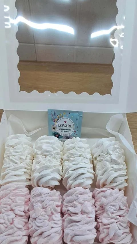 Gift box containing white and pink marshmallow candies with Lovare tea packet, decorated with wavy-edged window frame