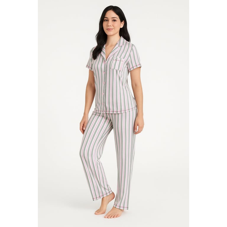 Woman wearing a white and gray striped short-sleeve pajama set standing against a neutral background