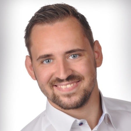 Professionelles Porträt von M.Sc. Carsten Hahn, lächelnd, in weißem Hemd vor neutralem Hintergrund