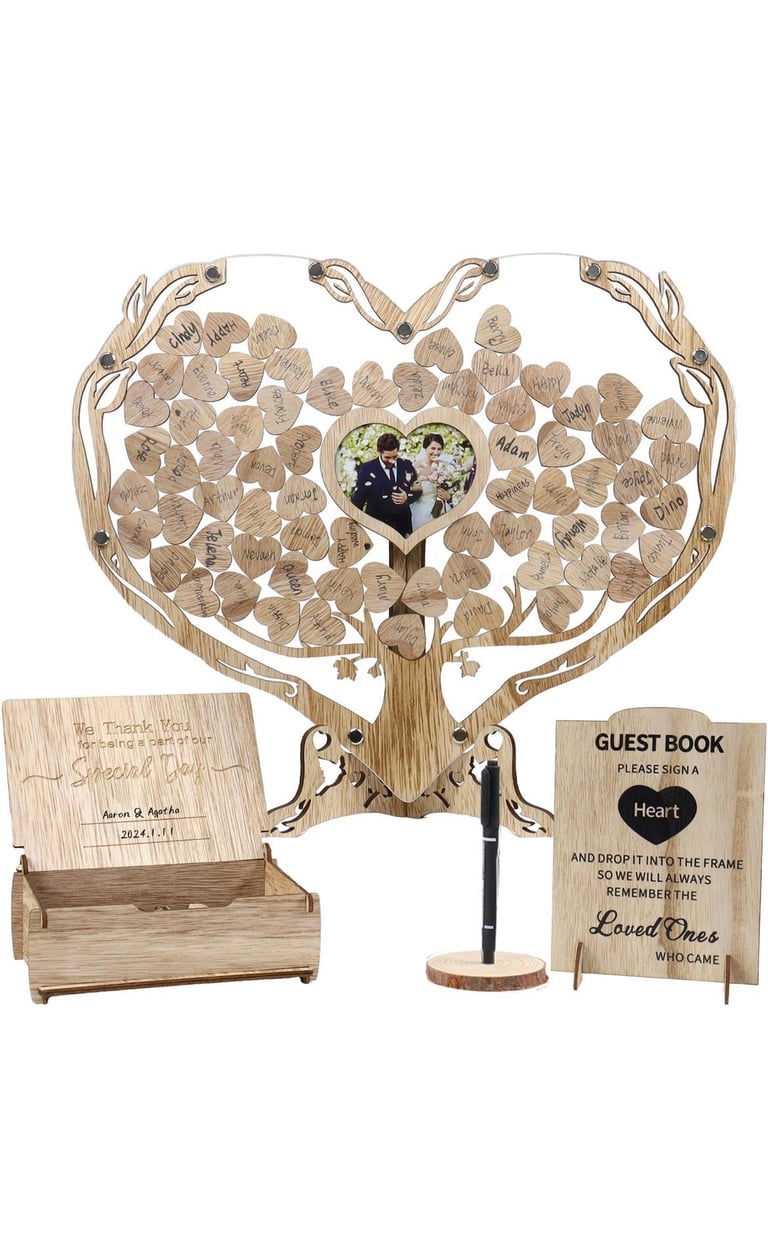 Wooden heart-shaped guest book tree with hanging leaf ornaments, photo frame, and instruction card for wedding or event signings