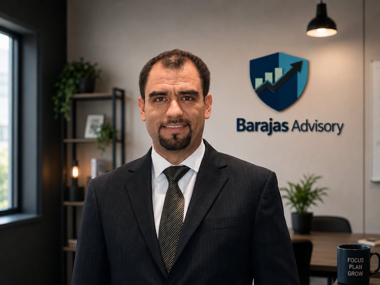 Professional man in business suit standing in modern office with Barajas Advisory logo on wall behind him