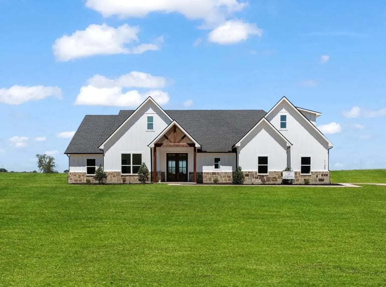 Modern white farmhouse exterior with gray roof and brick accents — Southern Shore custom home