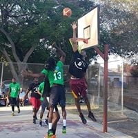 Basketball players jumping and shooting during an outdoor game