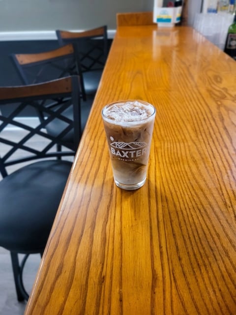 An iced coffee drink with whipped cream on a wooden table