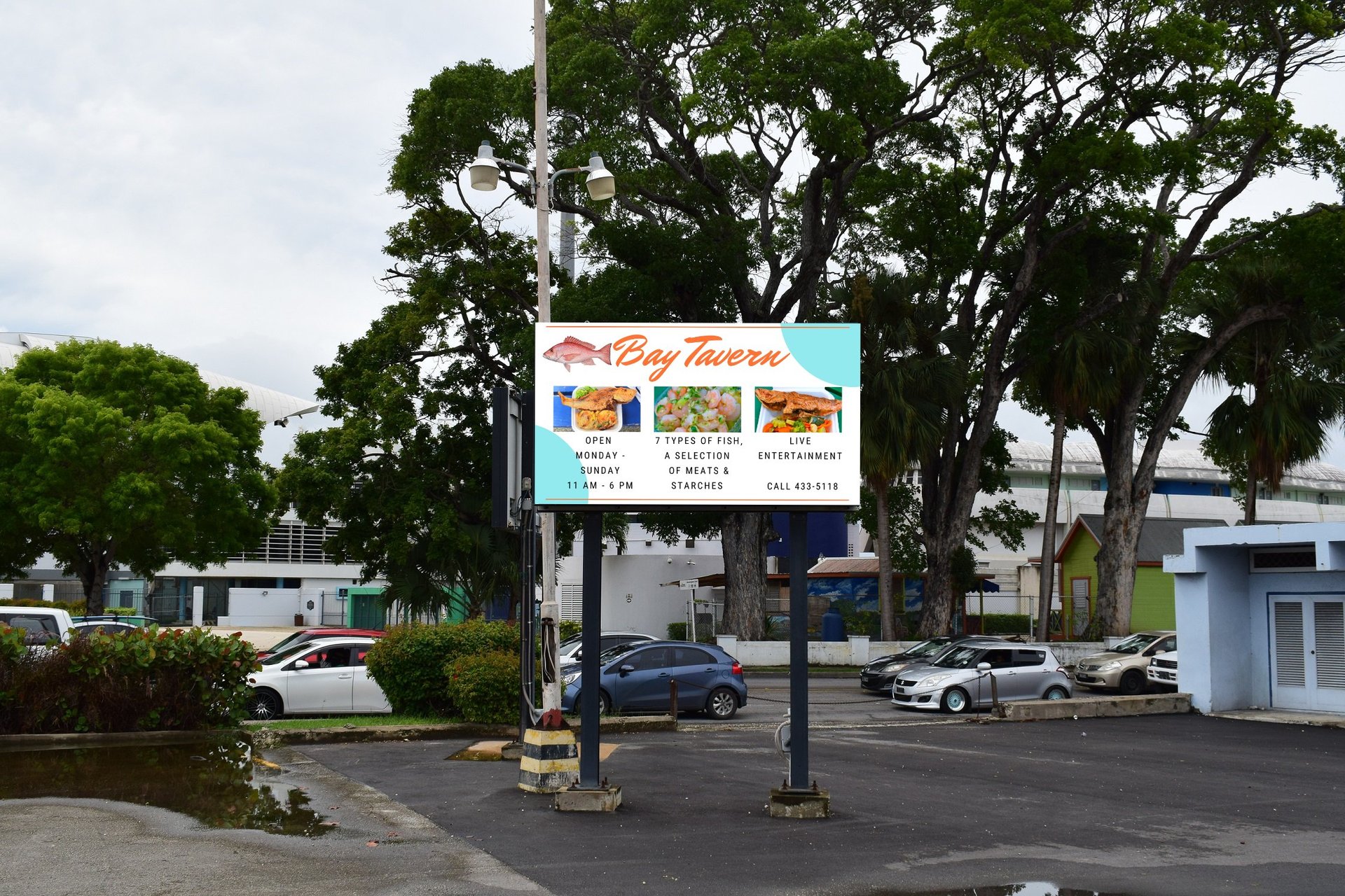 Digital billboard advertising local restaurants in a parking lot with tall trees and parked cars in background