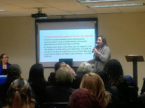 Conferencista presentando frente a pantalla con texto en español