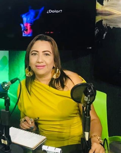 Conferencista en estudio de podcast con iluminación verde y aros dorados