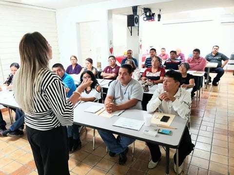 Mujer dirigiendo sesión de grupo en sala comunitaria