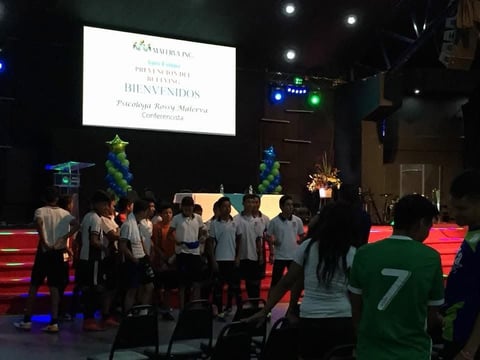 Grupo de niñas en escenario durante evento de prevención
