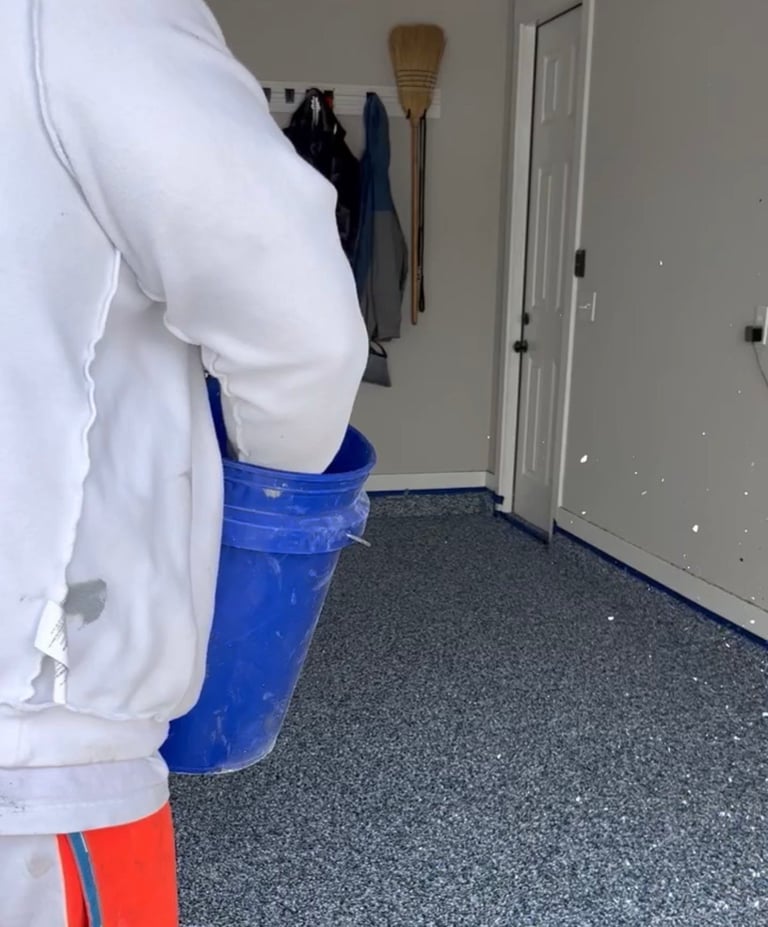 Person in white shirt holding blue bucket in hallway with gray floor and white doors
