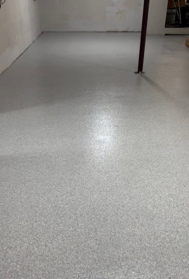 Empty room with polished gray concrete floor, white walls, and dark metal support column
