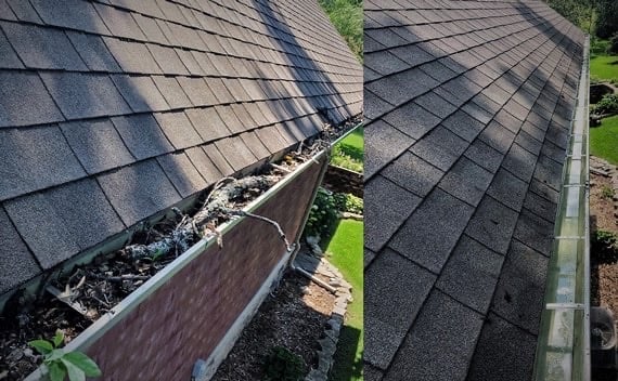 Close-up of roof gutter filled with leaves and debris, showing the valley between two roof sections with asphalt shingles