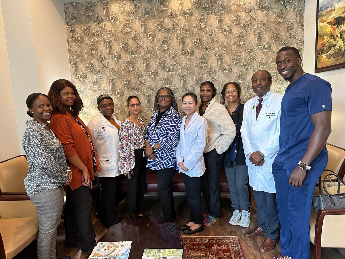 Group photo of diverse Wellspring Medical Center healthcare professionals posing together in the clinic office, including Dr. Ayeni in a white coat.