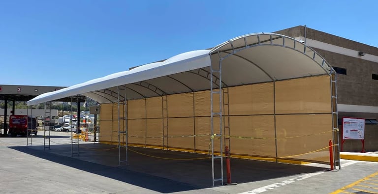 Estructura metálica en Tijuana — Nave industrial temporal con paneles de lona arena y estructura de acero bajo cielo azul