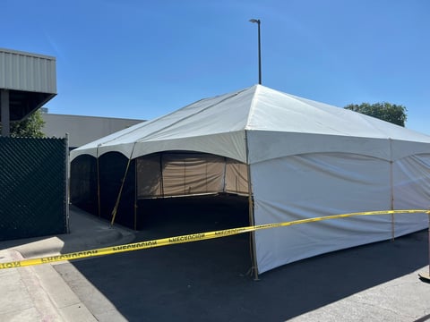 Carpa blanca con lona plastizada instalada en estacionamiento vacío