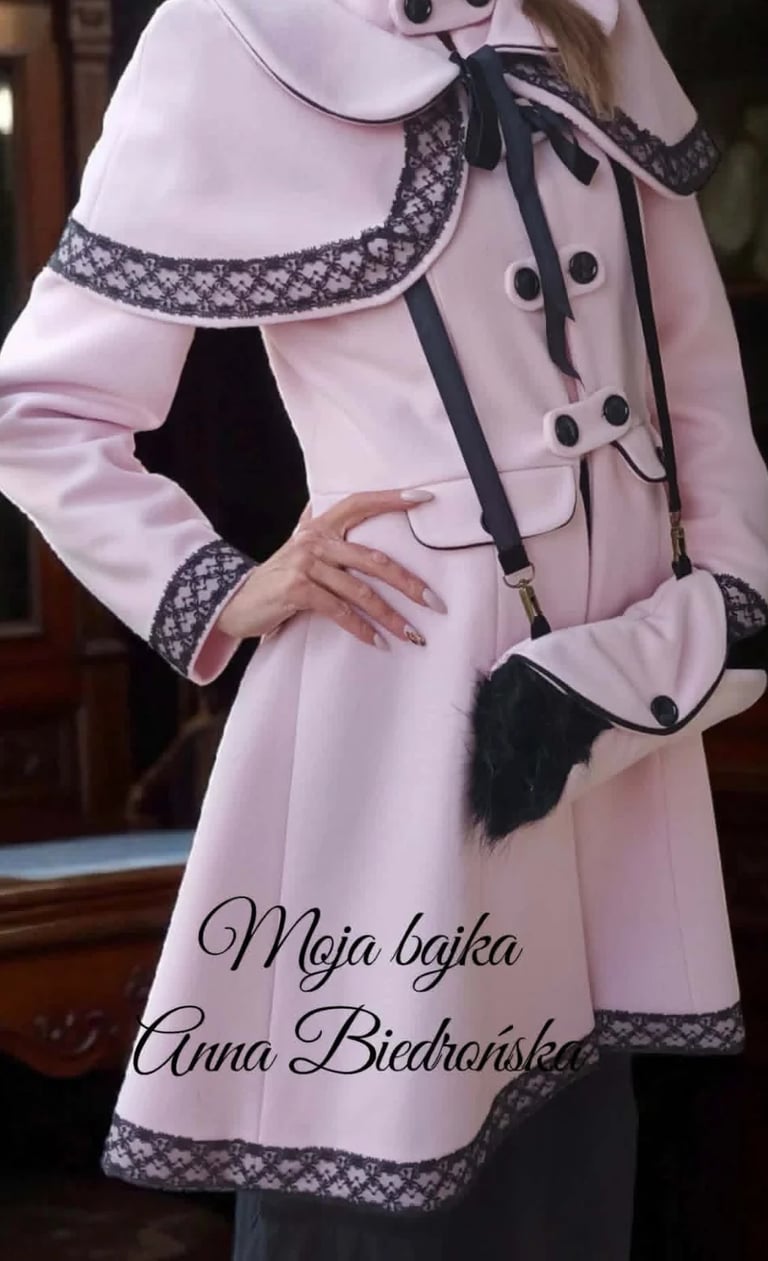 Woman wearing a pink coat with black lace trim and matching purse, text reads Moja bajka Anna Biedroaiska