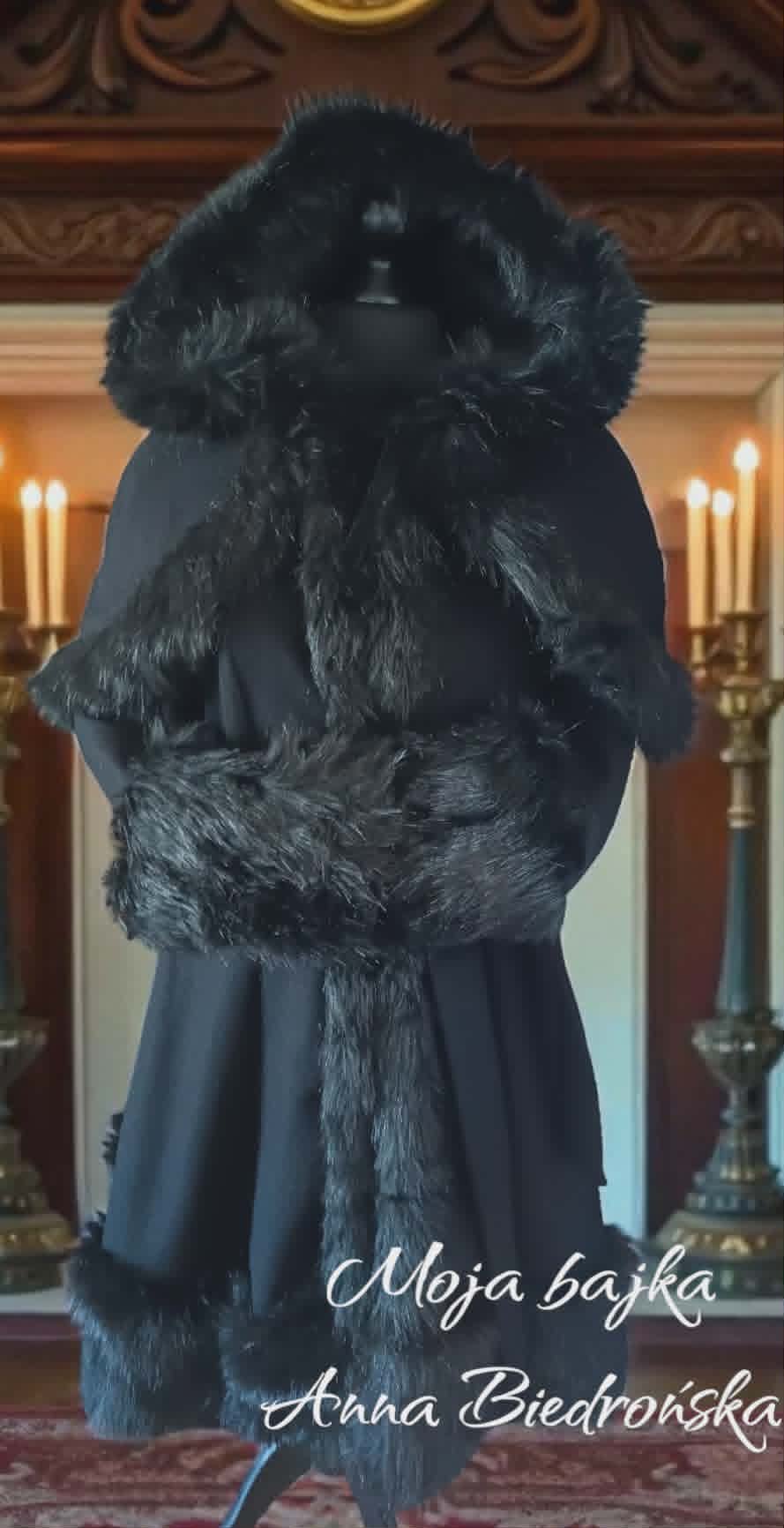 Woman from behind wearing elegant black coat with fur collar and trim in ornate interior with candelabras