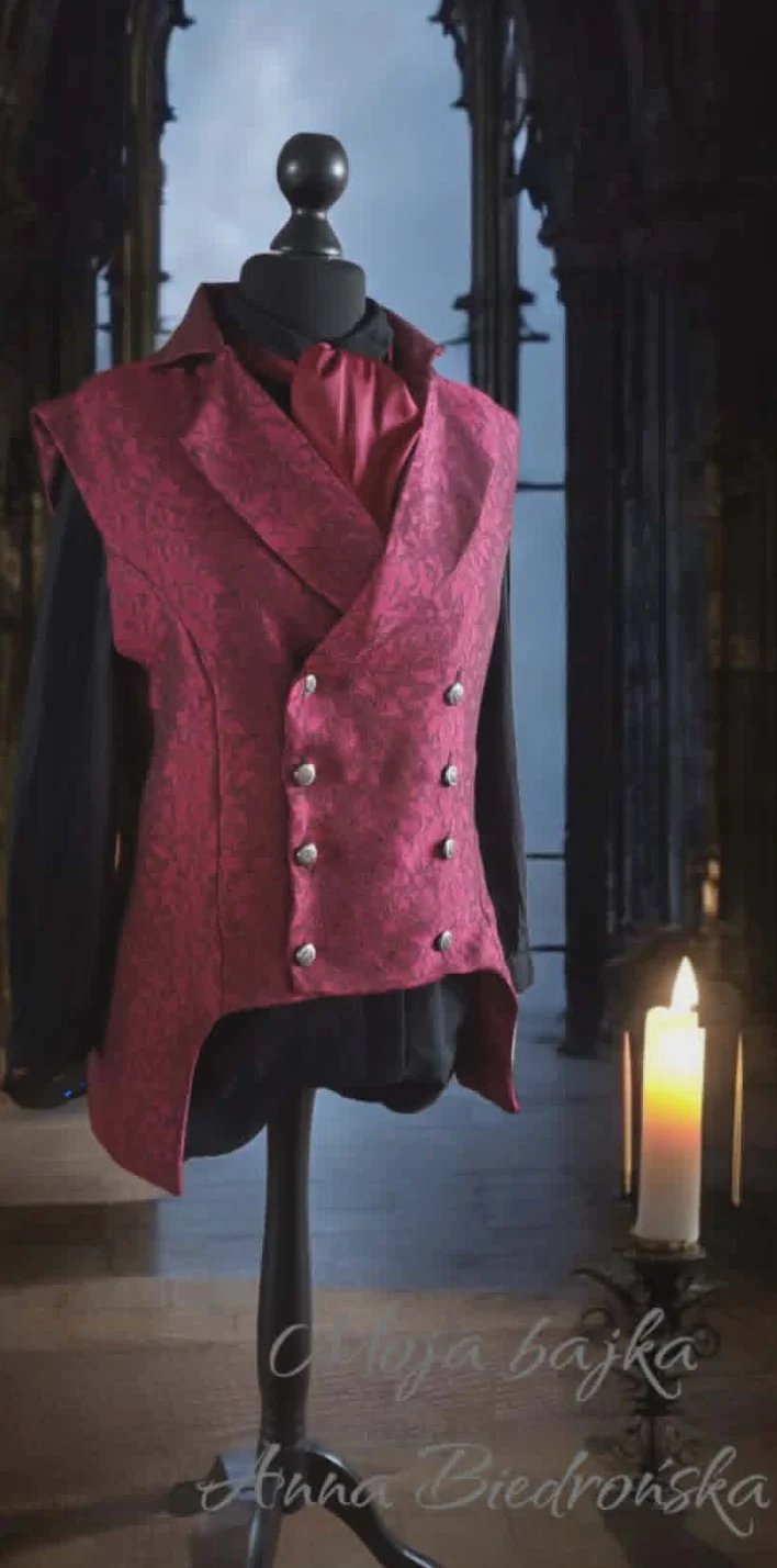 Pink velvet double-breasted vest displayed on a mannequin in a gallery setting with candles and ornate architectural backdrop