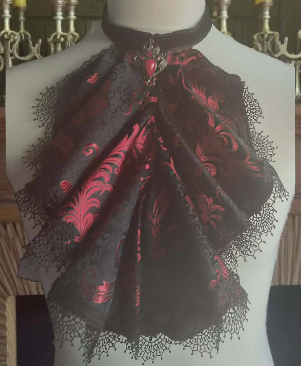 Elegant black lace shawl with red damask pattern draped on a dress form in an ornate interior setting
