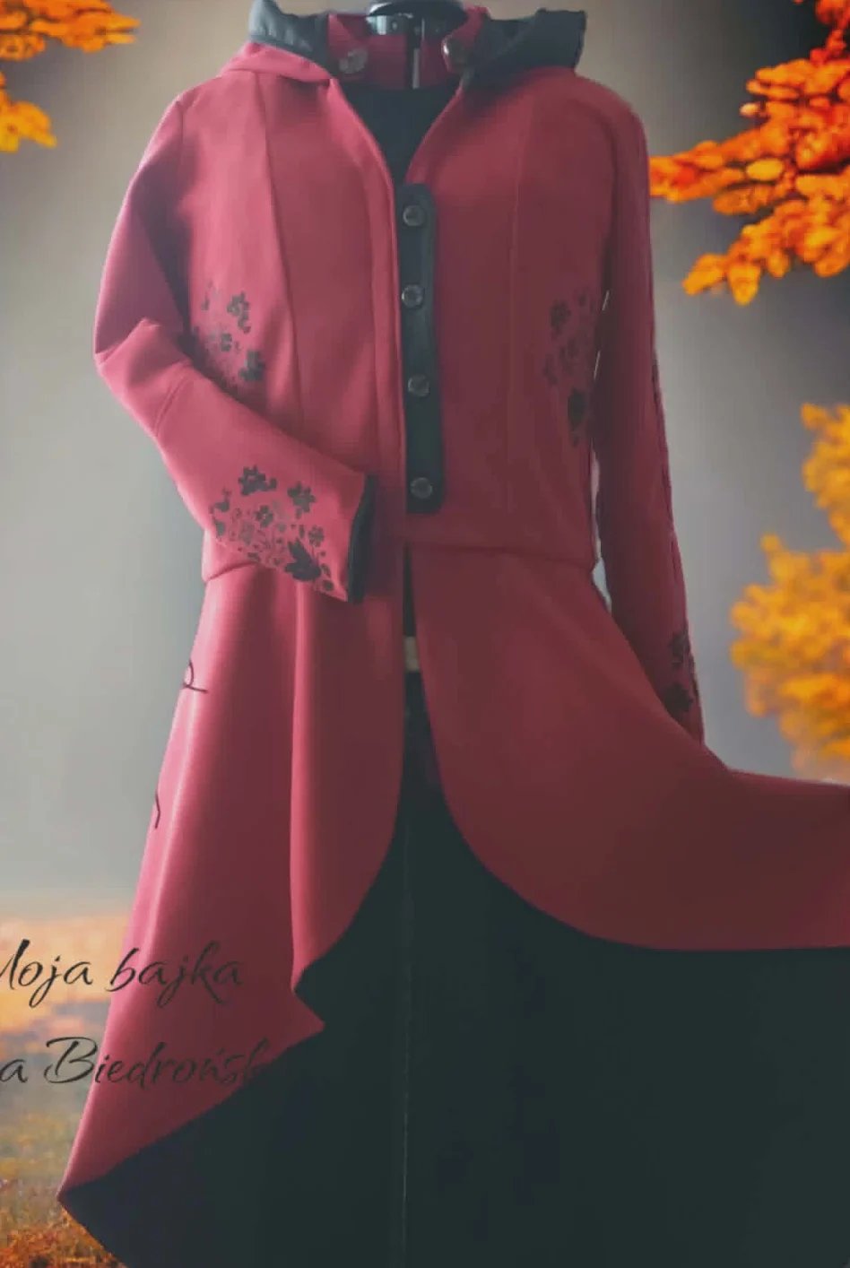 Pink embroidered jacket with floral details on sleeves, displayed against autumn backdrop with orange leaves and black interior lining