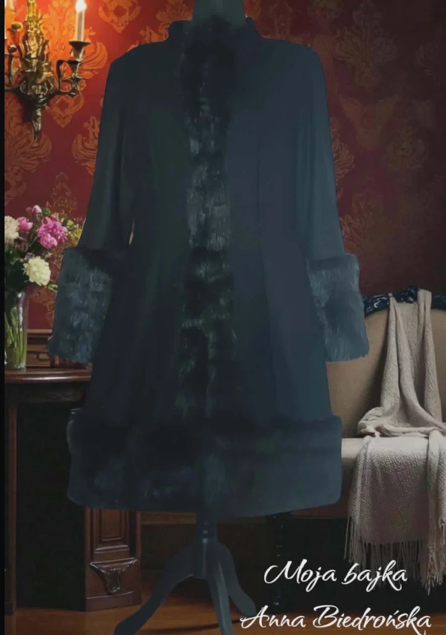 Black coat displayed on mannequin with fur trim, shown in elegant interior with ornate wallpaper and flowers