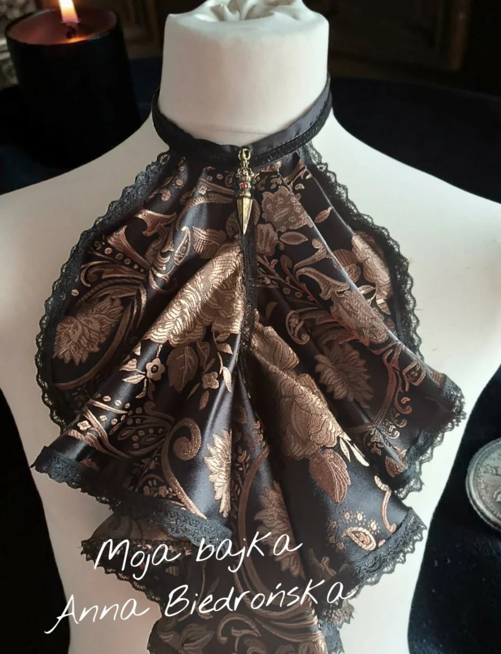 Ornate bronze and black patterned choker necklace with lace trim on a white bust display form