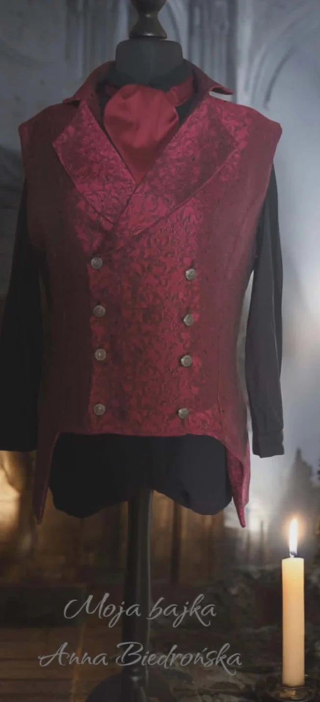 Burgundy double-breasted vest with damask pattern displayed on dress form with black sleeves and candle beside it