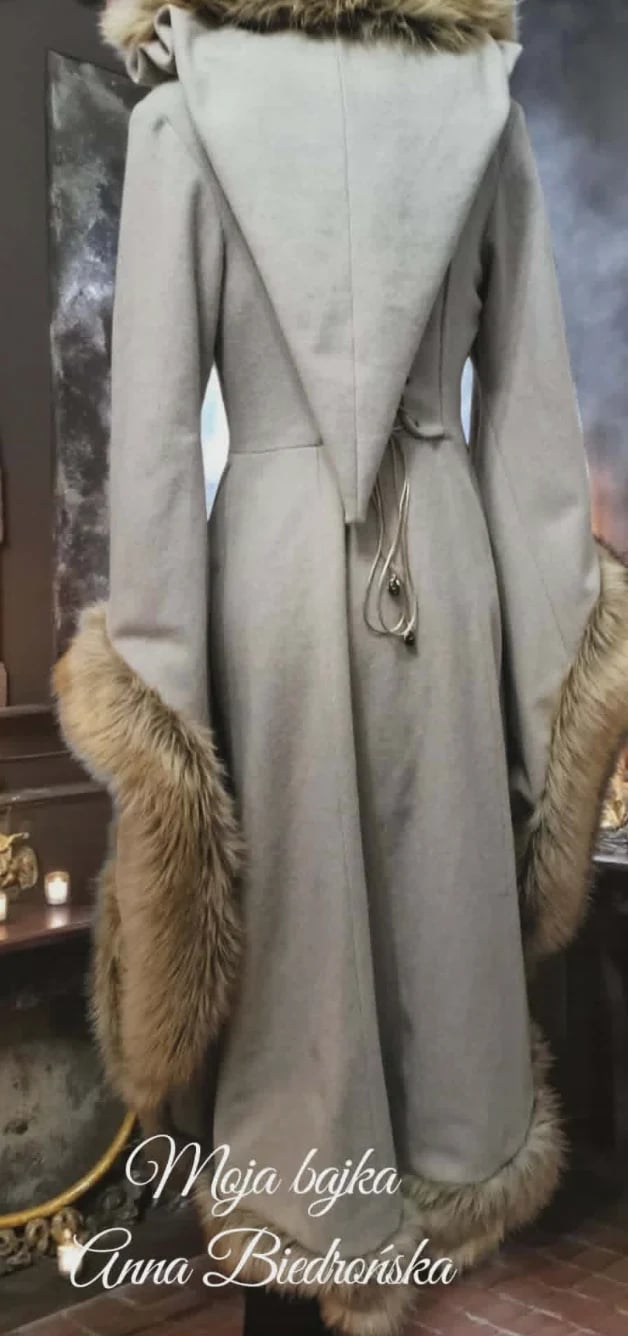 Back view of elegant beige wool coat with fur collar and cuffs, featuring a drawstring waist and long sleeves