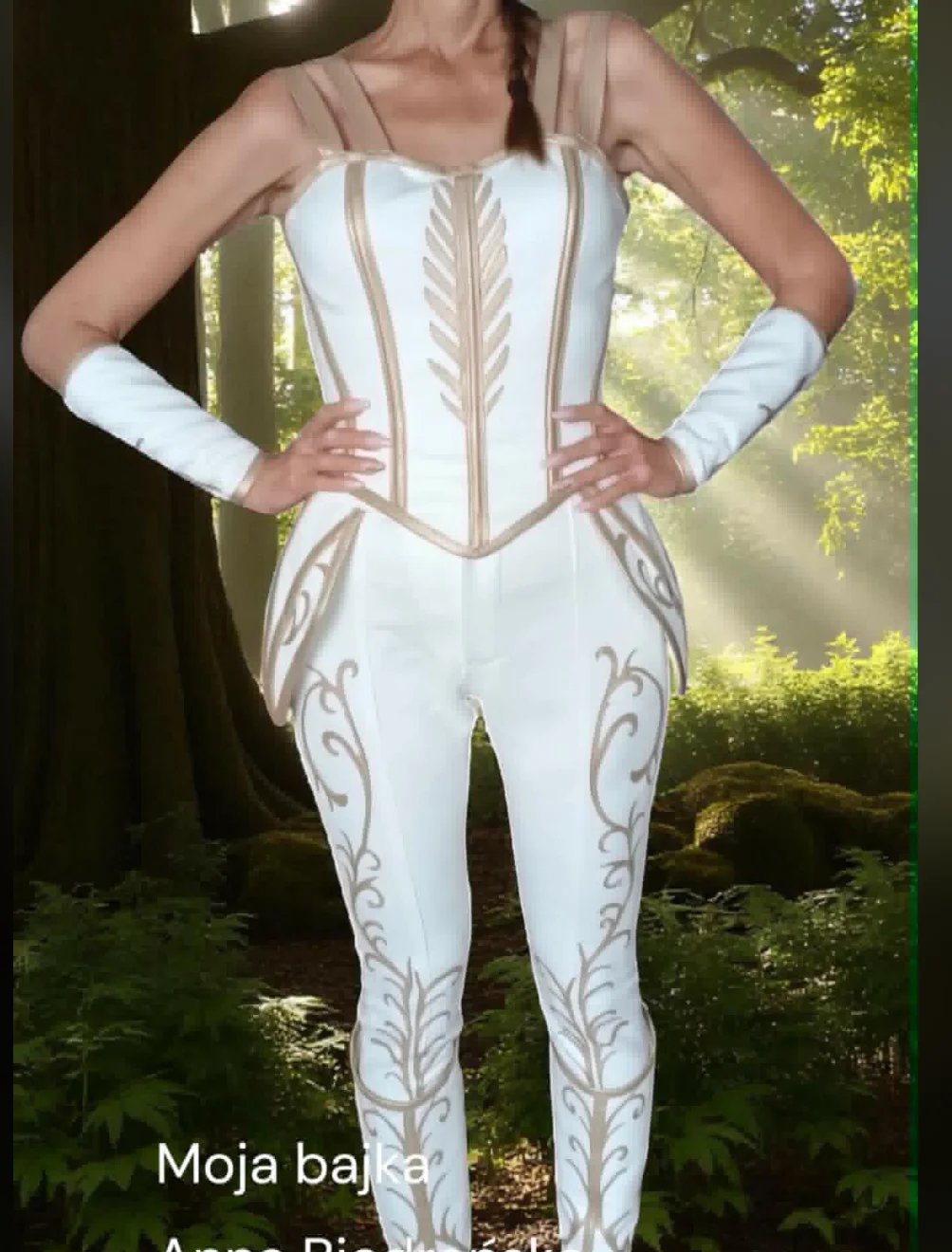 Woman wearing white and beige ornate corset-style bodysuit with decorative leaf patterns standing in forest setting