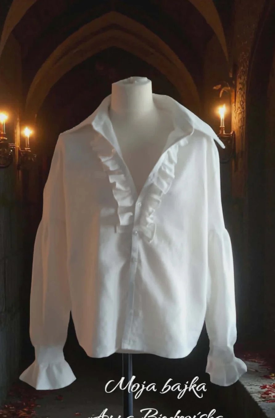 White ruffled blouse on mannequin displayed in a dimly lit archway with stone walls and lanterns