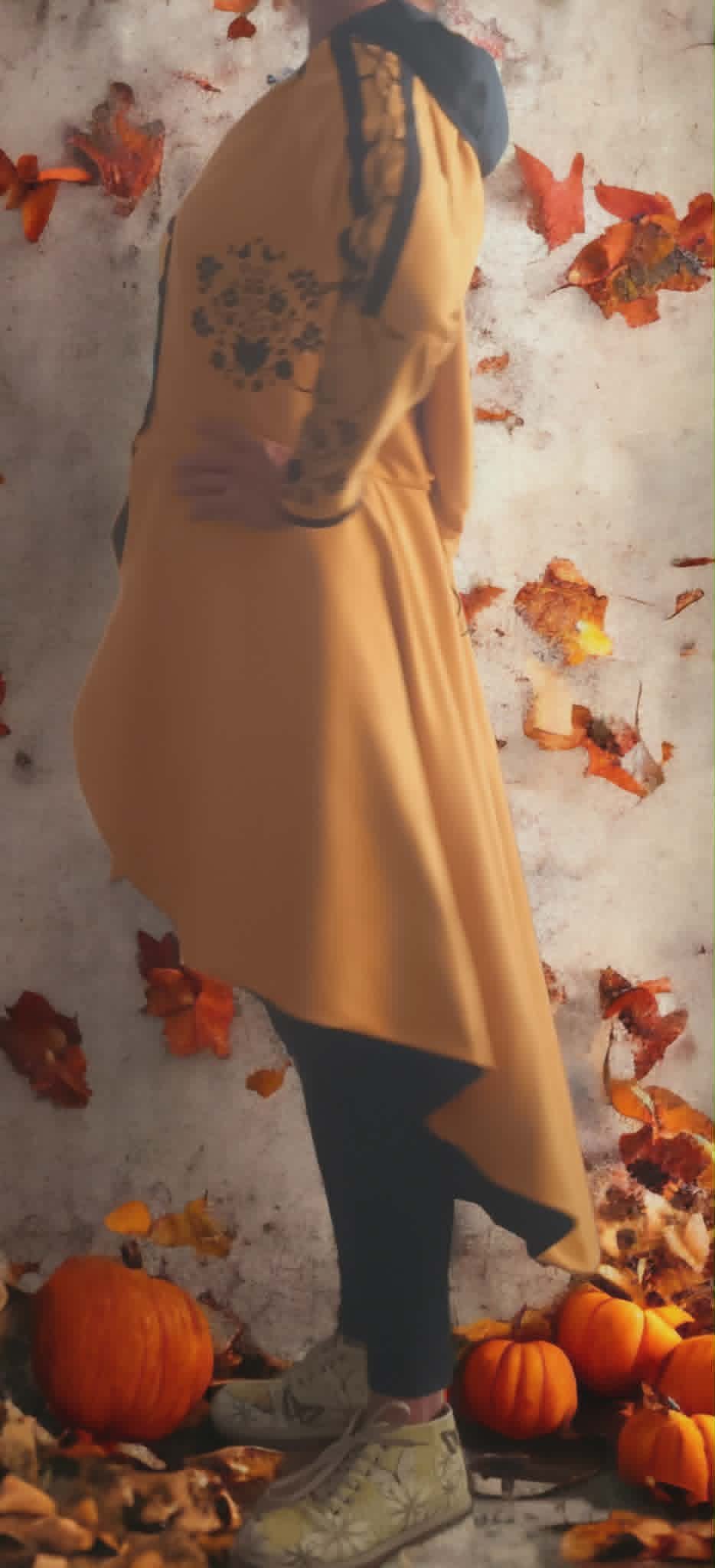 Person with back tattoo wearing yellow shirt posed against white wall with autumn leaves and pumpkins