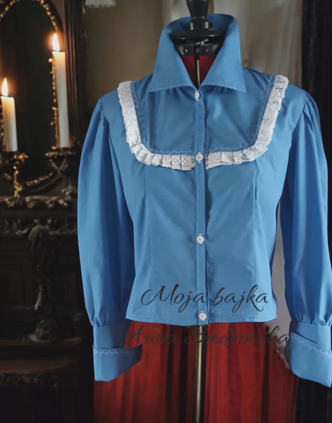 Blue vintage blouse with white lace collar on dress form, displayed against dark background with candles