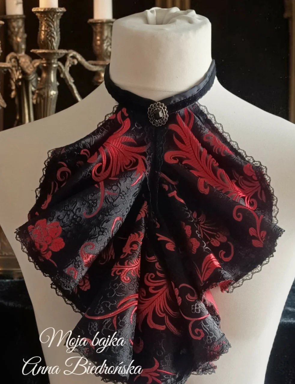 Mannequin wearing ornate red and black damask fabric collar with lace edges and decorative choker detail